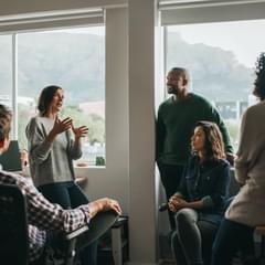 Diverse designers discussing a project together in their office while standing and sitting casually
