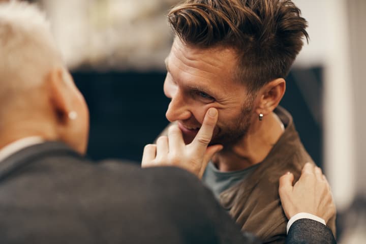 Happy young man talking to mature woman and smiling during their meeting.