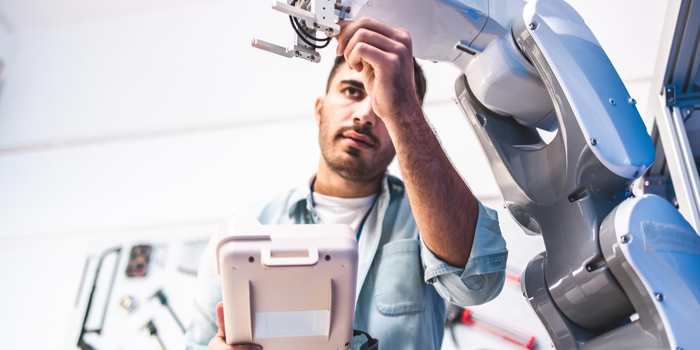 automation robot arm serviced by engineer