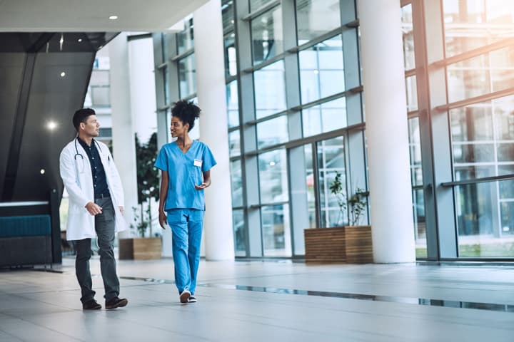 Shot of medical practitioners having a conversation in a hospital while walking