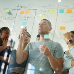 Cropped shot of a group of young designers planning on a glass board.
