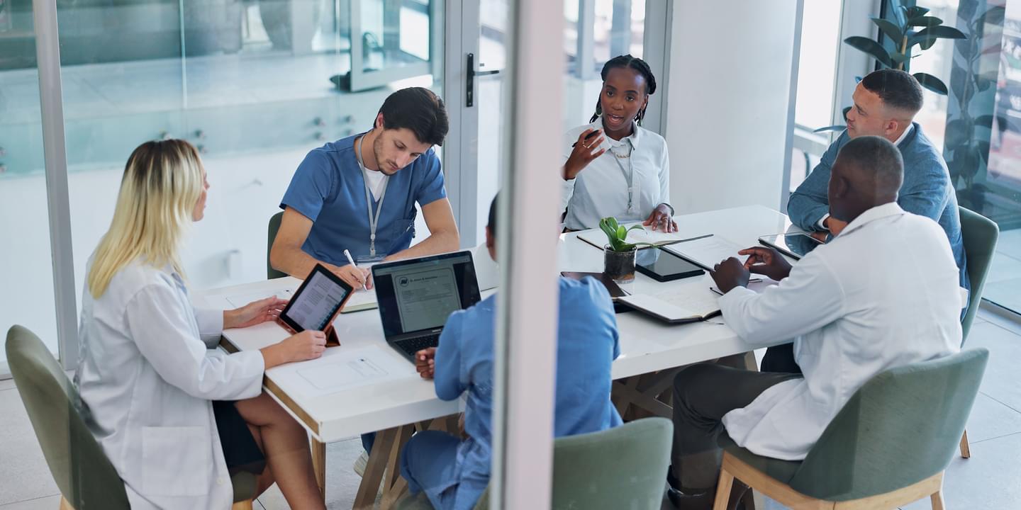 Medical Workers In Glass Office Having Conversation With Computers