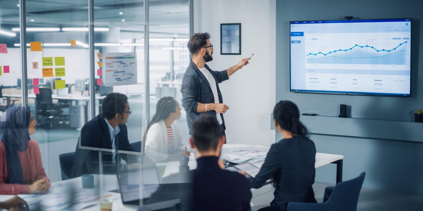 Businessman Leads Meeting with Data on Screen