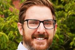 Image of Propeller's Silicon Valley managing director, David Woltze. He wears black-framed glasses and a pale blue button-up shirt with a fine dark blue dot pattern.