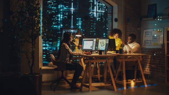 Diverse Team of Colleagues Working in the Office Together at Night