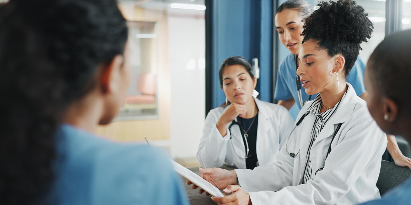 Female Doctor With Tablet During Meeting