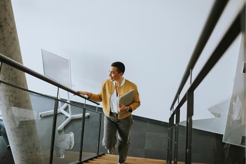 Momentum woman walking up steps with laptop