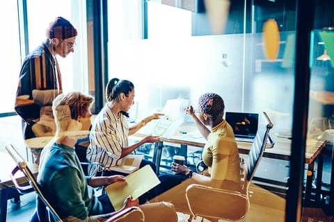 Team working together in glass office